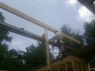 Carpenter setting a ridge beam over a new addition frame — Ice Dam Removal by Roofing Brothers in Seneca
